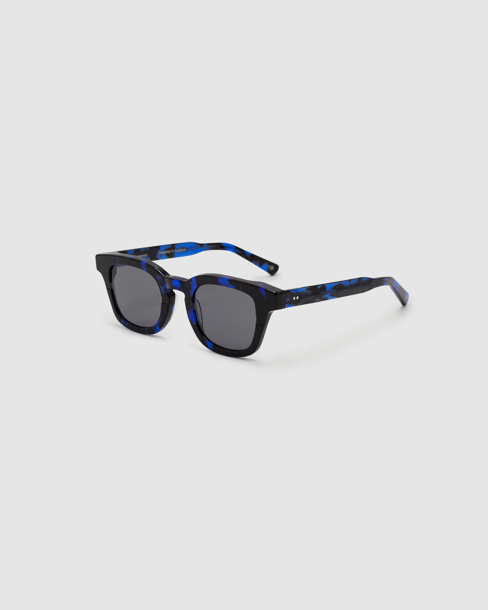 Bowie Polarised Sunglasses by Tribu Eyewear — Electro Blue Puddle classic acetate frame, side view light grey background.