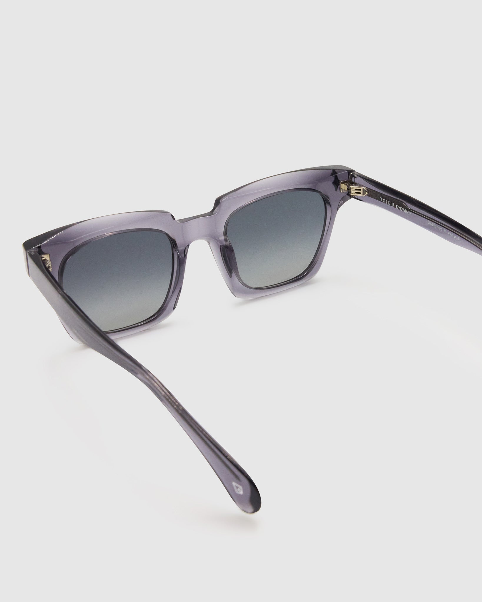 Brutal 1.0 Polarised Sunglasses by Tribu Eyewear — Smoke rectangular acetate frame, grey grad lens, detailed view light grey background.