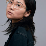 Brutal 2.0 Optical by Tribu Eyewear — Champagne Crystal round optical frame, female model studio lighting. 