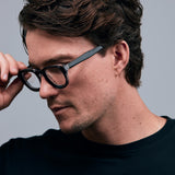 Brutal 4.0 Optical by Tribu Eyewear — Black on Crystal round optical frame, male model side view studio lighting. 