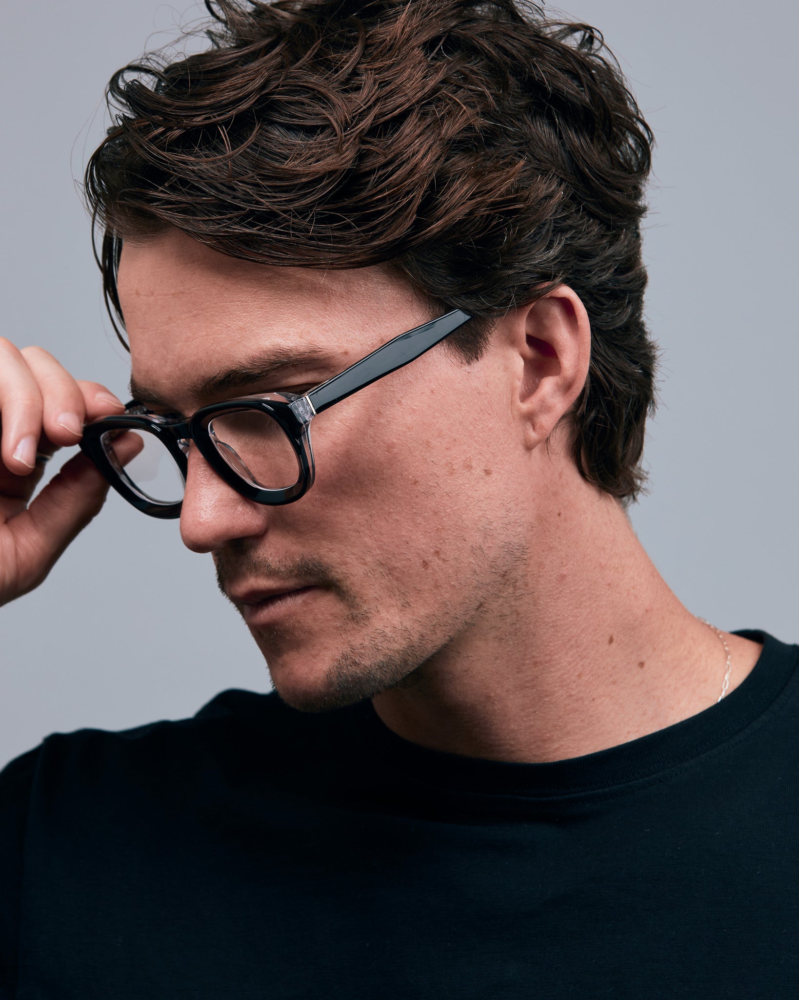 Brutal 4.0 Optical by Tribu Eyewear — Black on Crystal round optical frame, male model side view studio lighting. 