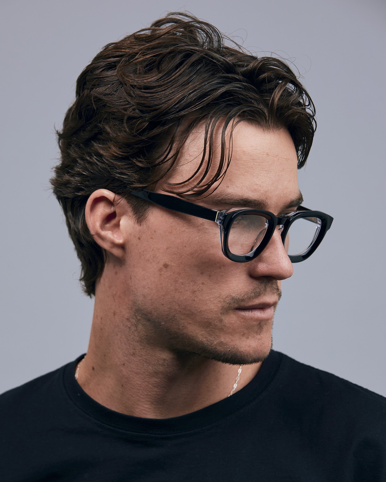 Brutal 4.0 Optical by Tribu Eyewear — Black on Crystal round optical frame, male model side view studio lighting. 