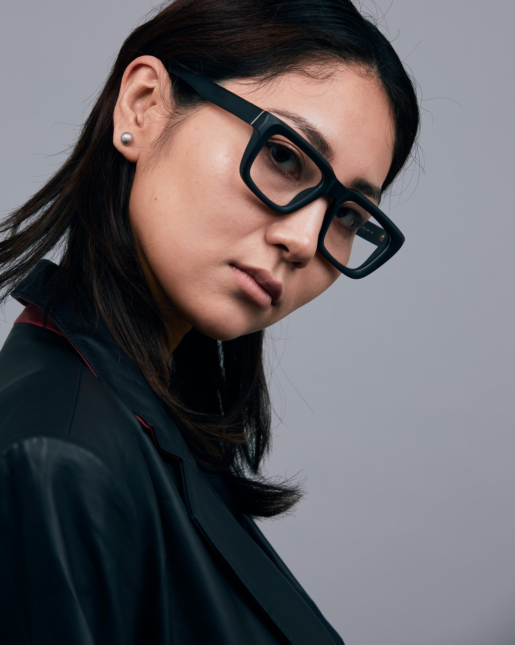 Brutal 5.0 Optical by Tribu Eyewear — Matte Black square optical frame, female model against a grey background. 