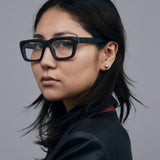 Brutal 5.0 Optical by Tribu Eyewear — Matte Black square optical frame, female model against a grey background. 