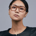 Marley Optical by Tribu Eyewear — Champagne crystal acetate aviator optical frame, female model against a grey background. 