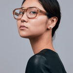 Marley Optical by Tribu Eyewear — Champagne crystal acetate aviator optical frame, female model against a grey background. 