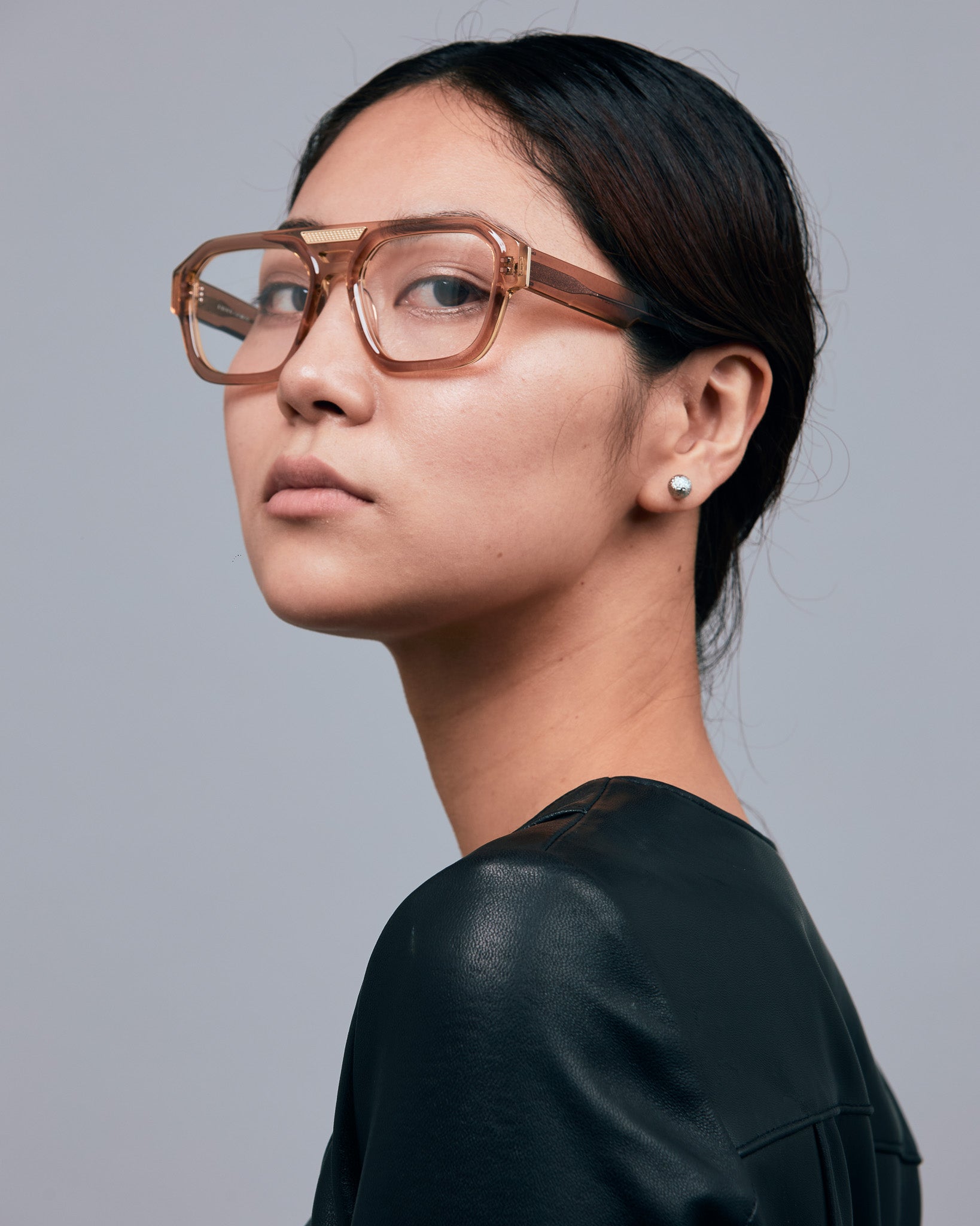 Marley Optical by Tribu Eyewear — Champagne crystal acetate aviator optical frame, female model against a grey background. 