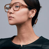 Marley Optical by Tribu Eyewear — Champagne crystal acetate aviator optical frame, female model against a grey background. 