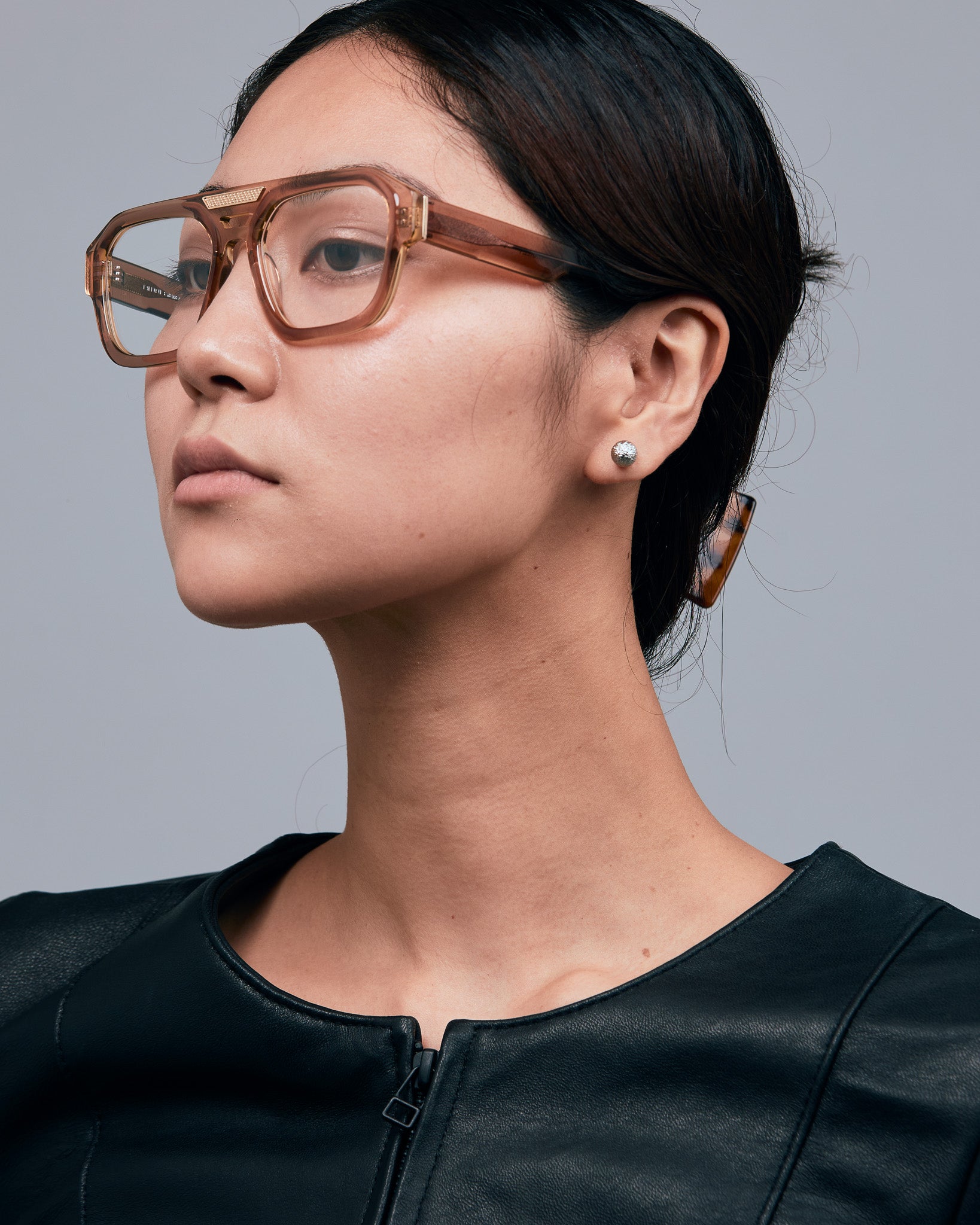 Marley Optical by Tribu Eyewear — Champagne crystal acetate aviator optical frame, female model against a grey background. 