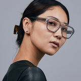Marley Optical by Tribu Eyewear — Smoke crystal acetate aviator optical frame, warn by a female model against a grey background. 