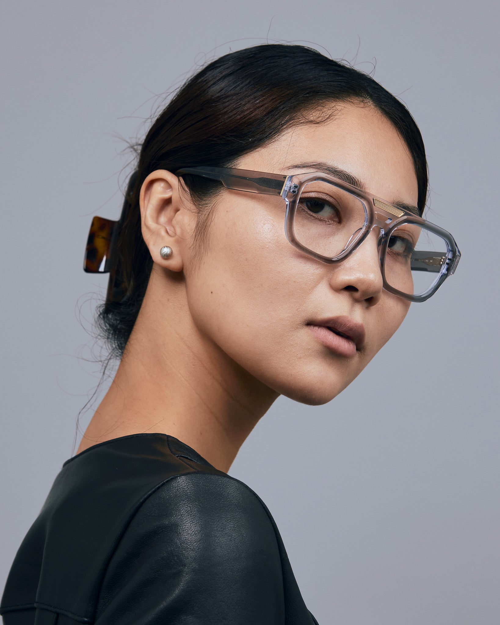 Marley Optical by Tribu Eyewear — Smoke crystal acetate aviator optical frame, warn by a female model against a grey background. 