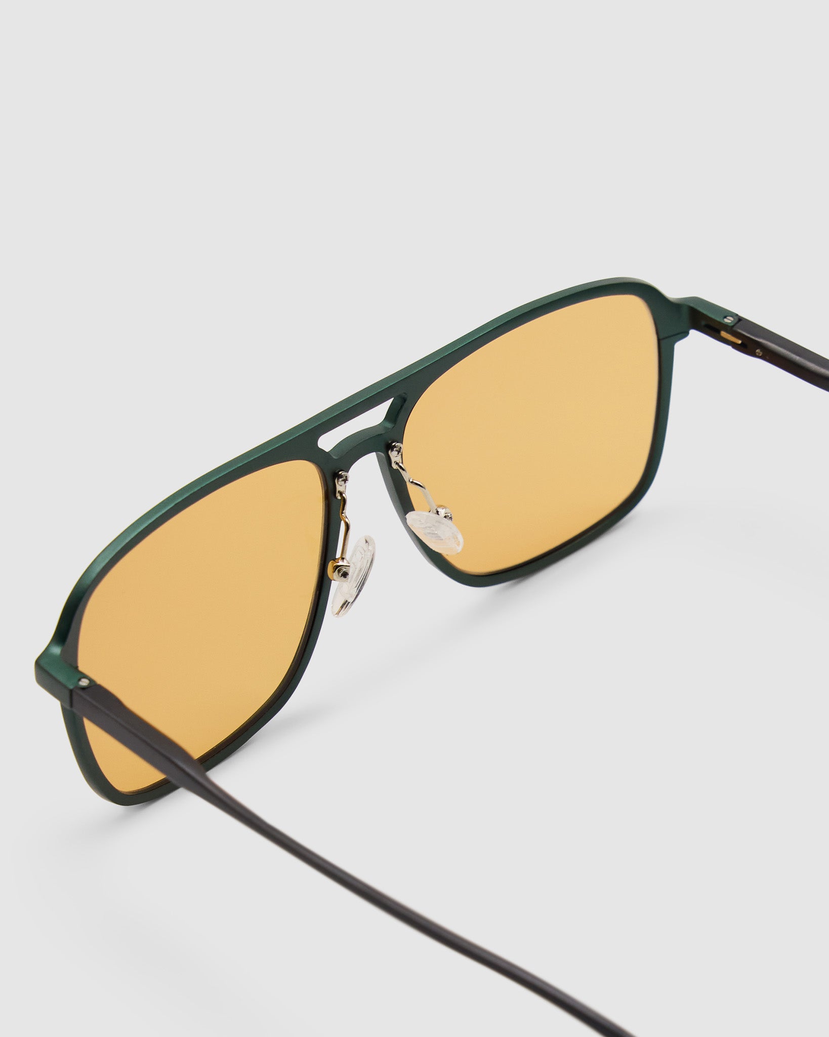 Oscar Sunglasses by Tribu Eyewear — Forest Green Aluminium Aviator frame, Desert Orange lens, detailed view against white background.