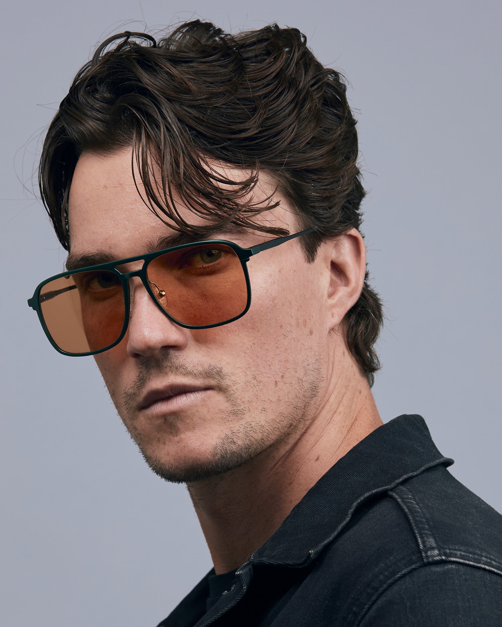 Oscar Sunglasses by Tribu Eyewear — Forest Green Aluminium Aviator frame, Desert Orange lens male model against white background.