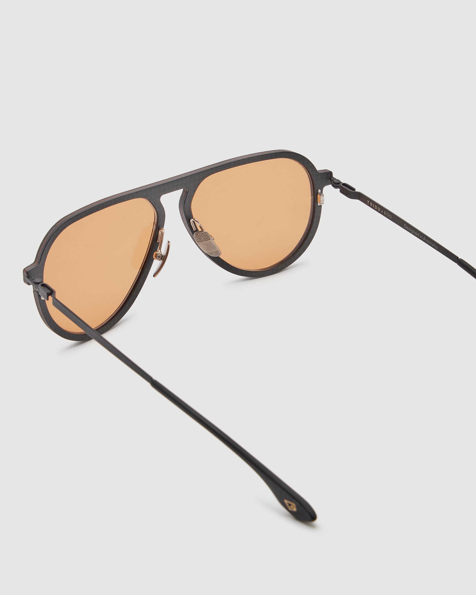 TRIBU Carbon 2.0 Black carbon fibre sunglasses with desert orange lenses, detailed view.