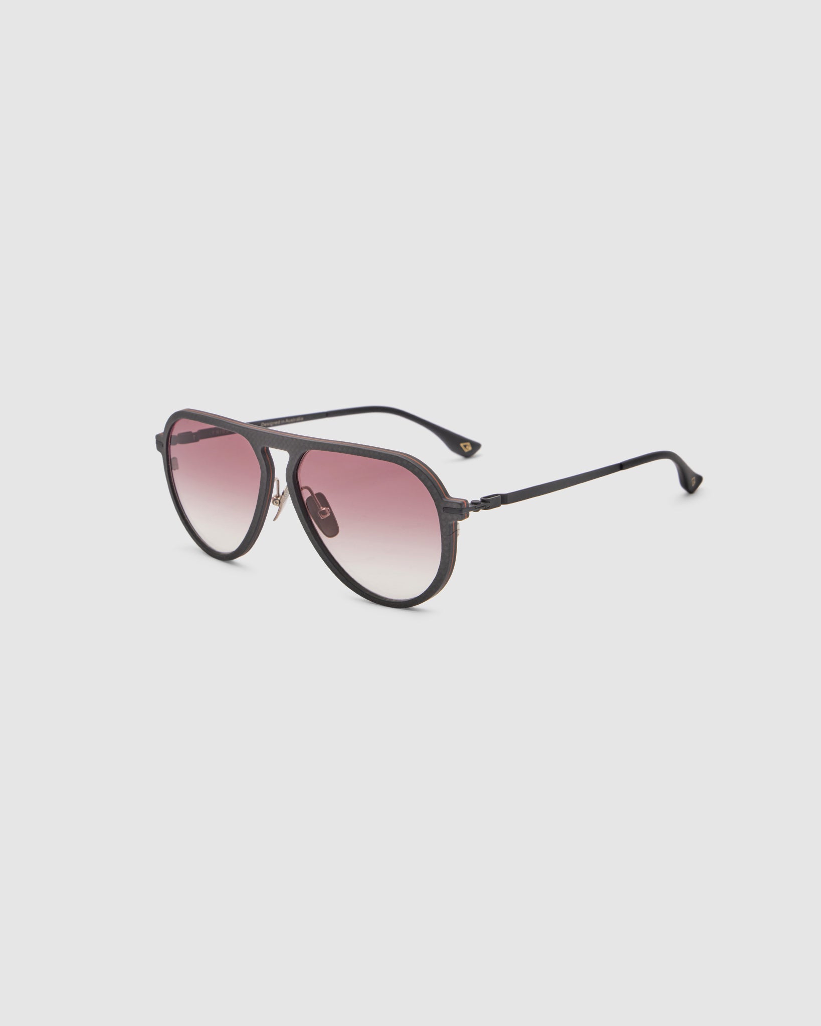 TRIBU Carbon 1.0 Black carbon fibre sunglasses with dark rose gradient lenses, side view.