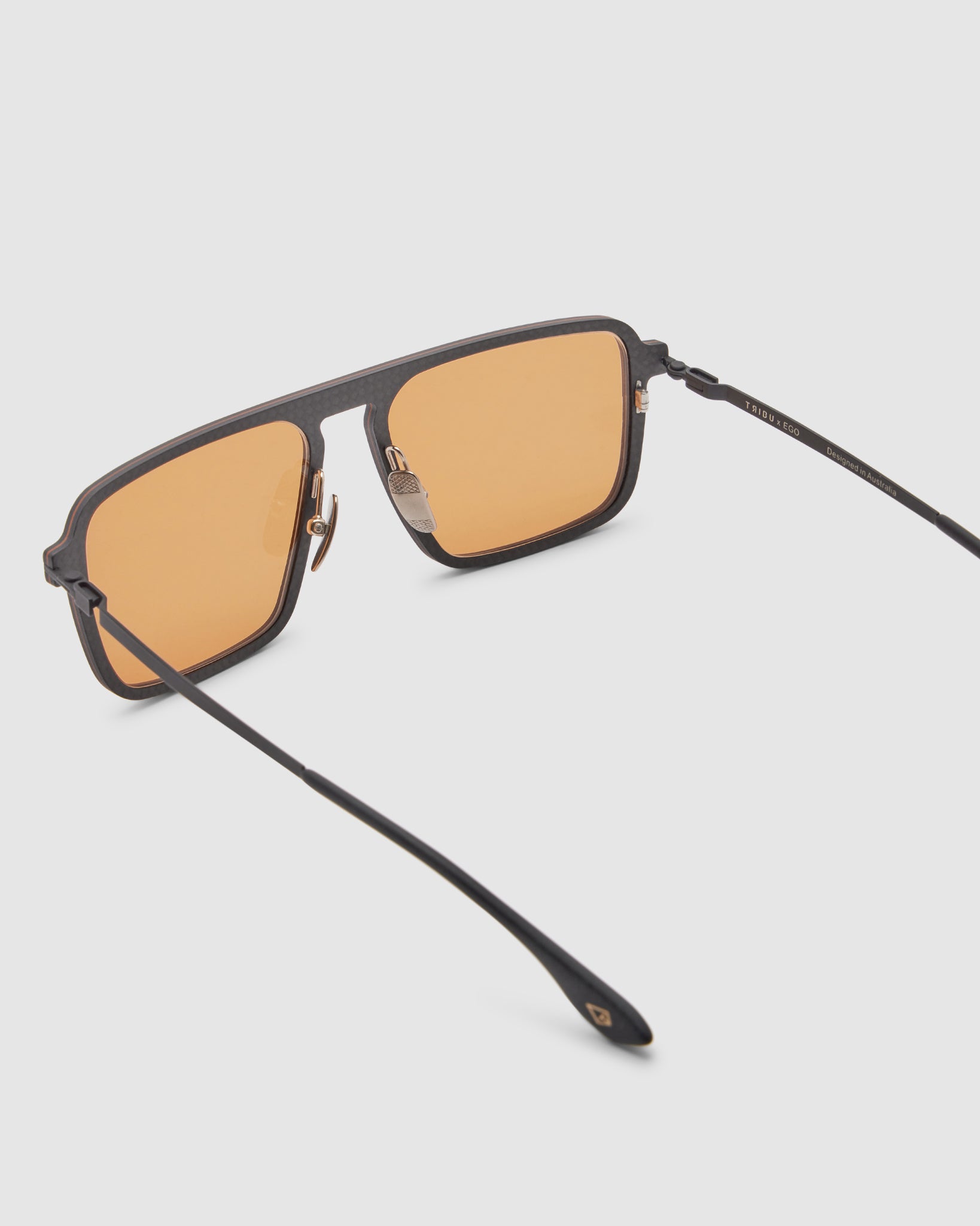 TRIBU Carbon 2.0 Black carbon fibre sunglasses with desert orange lenses, detailed view.
