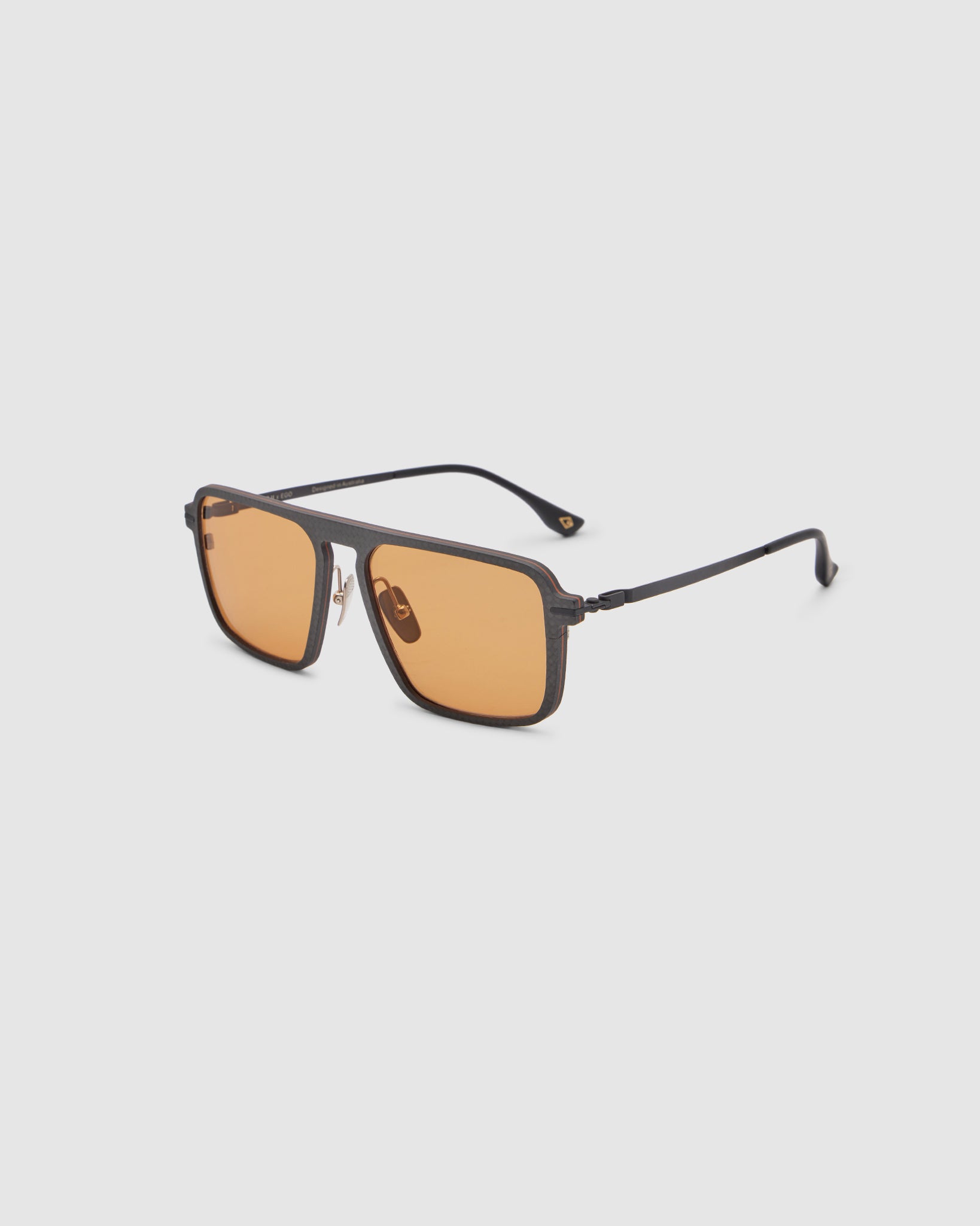 TRIBU Carbon 2.0 Black carbon fibre sunglasses with desert orange lenses, side view.