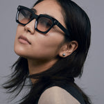 Brutal 1.0 Sunglasses by Tribu Eyewear — Black acetate square frame, dusk lens on female model grey background.