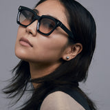 Brutal 1.0 Sunglasses by Tribu Eyewear — Black acetate square frame, dusk lens on female model grey background.