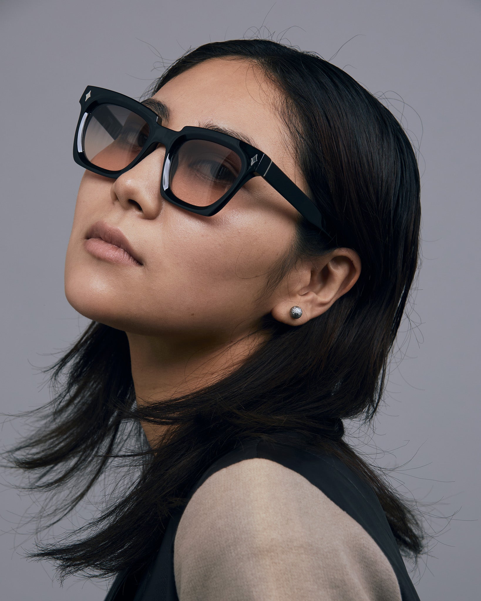 Brutal 1.0 Sunglasses by Tribu Eyewear — Black acetate square frame, dusk lens on female model grey background.