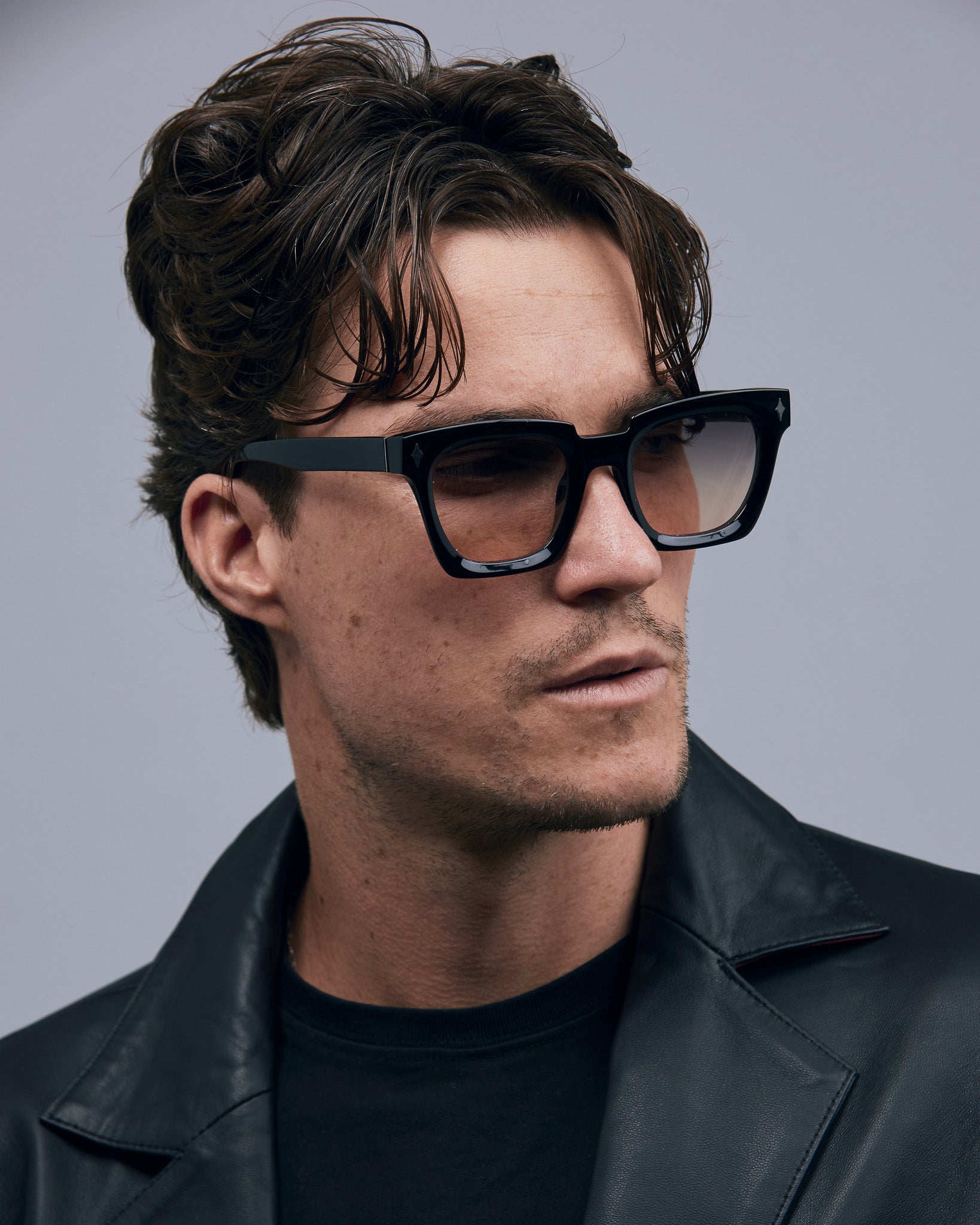 Brutal 1.0 Sunglasses by Tribu Eyewear — Black acetate square frame, dusk lens on male model grey background.