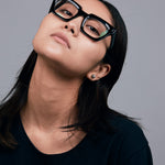 Brutal 1.0 Optical by Tribu Eyewear — Black square optical frame, female model in studio lighting. 
