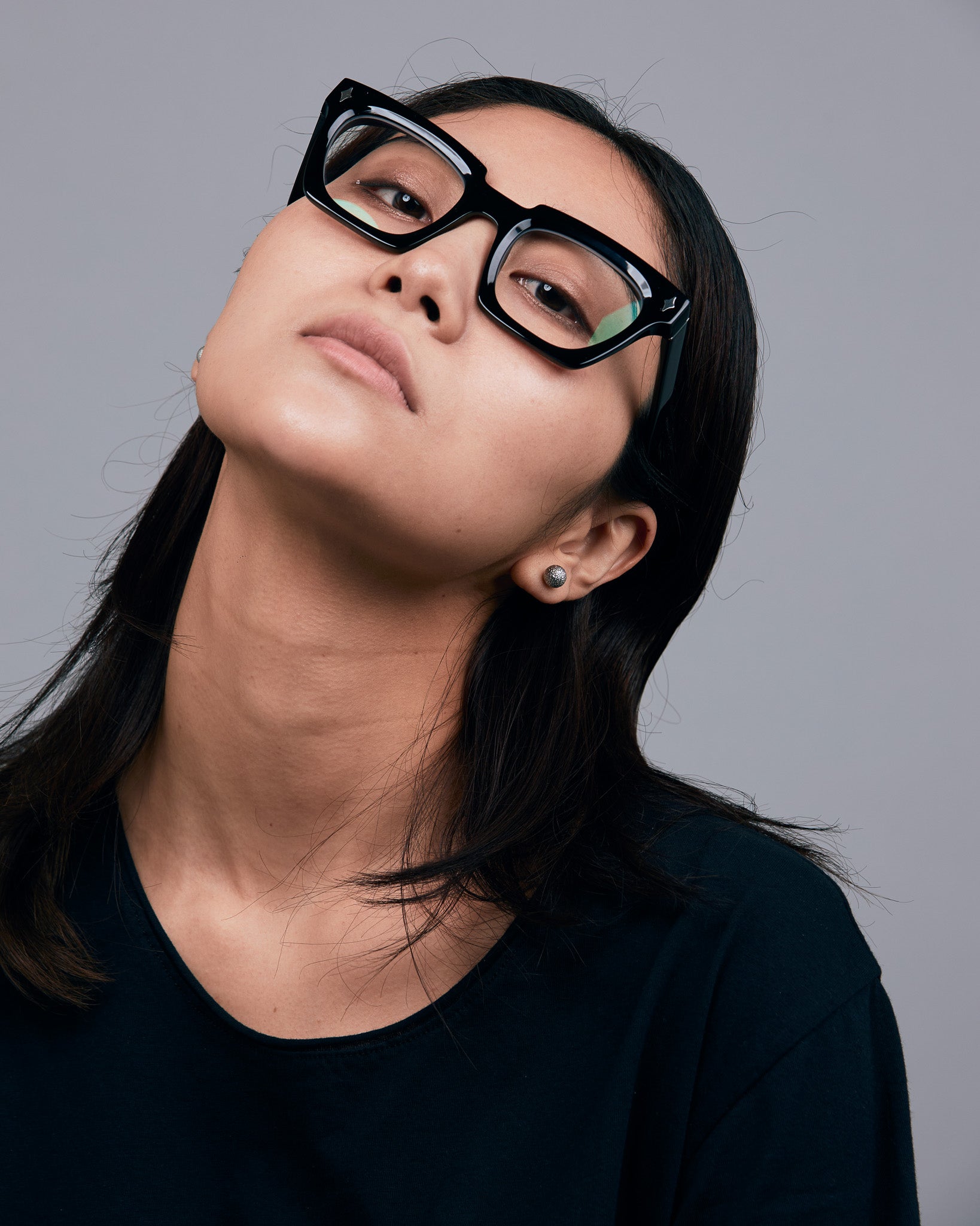 Brutal 1.0 Optical by Tribu Eyewear — Black square optical frame, female model in studio lighting. 
