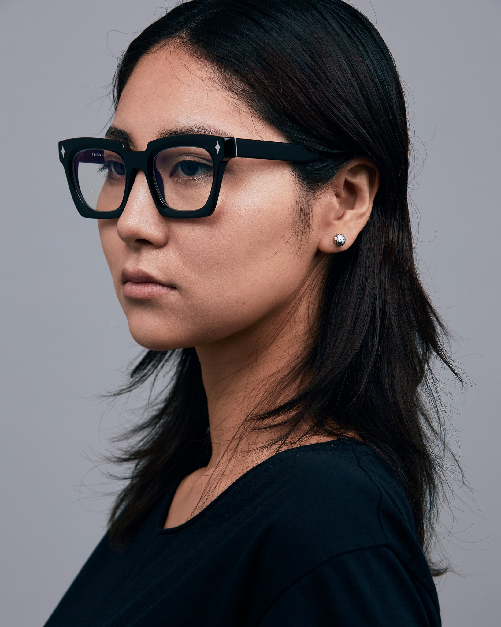 Brutal 1.0 Optical by Tribu Eyewear — Black square optical frame, female model in studio lighting. 

