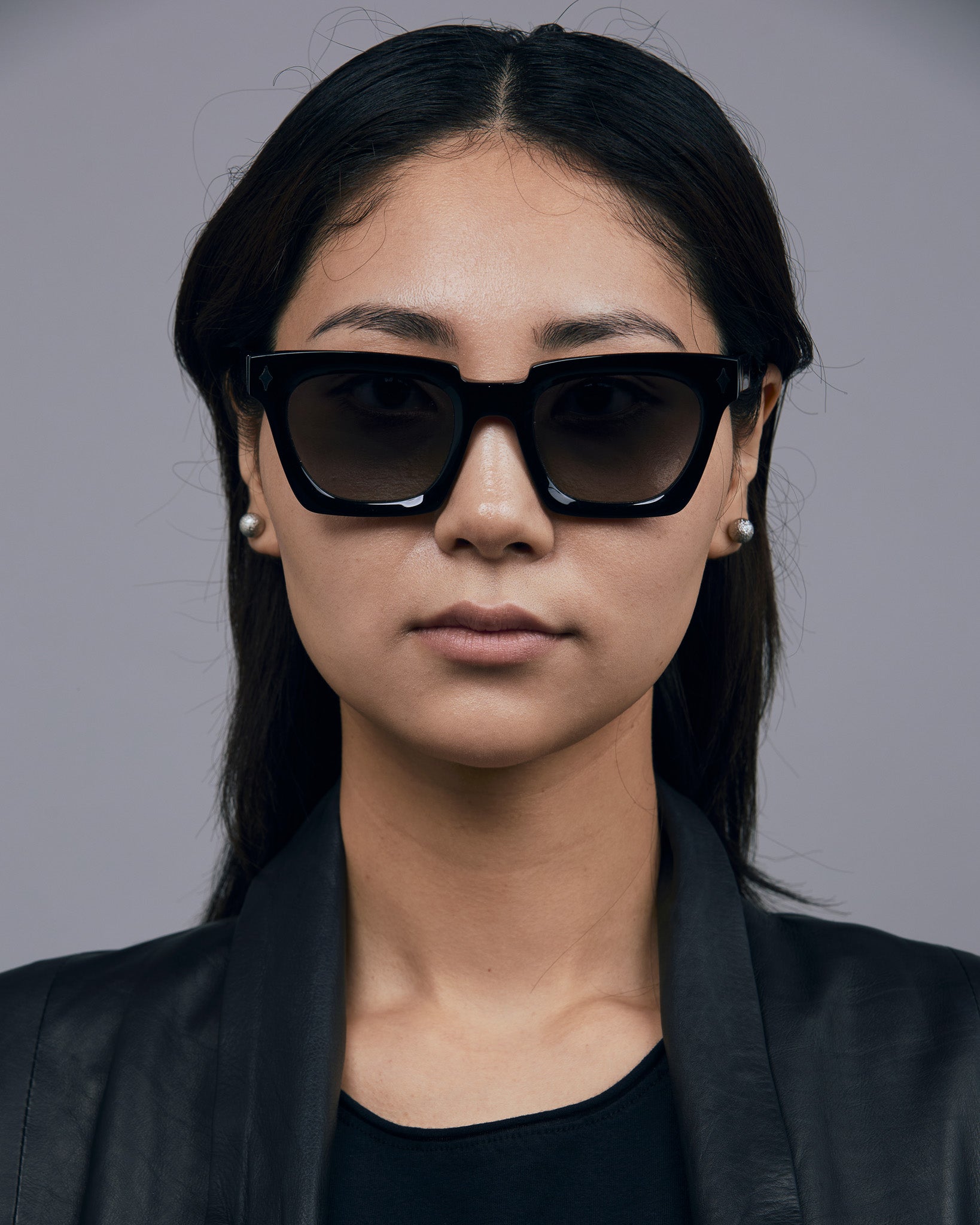 Brutal 1.0 Sunglasses by Tribu Eyewear — Black acetate square frame, grey gradient polarised, female model, grey background.