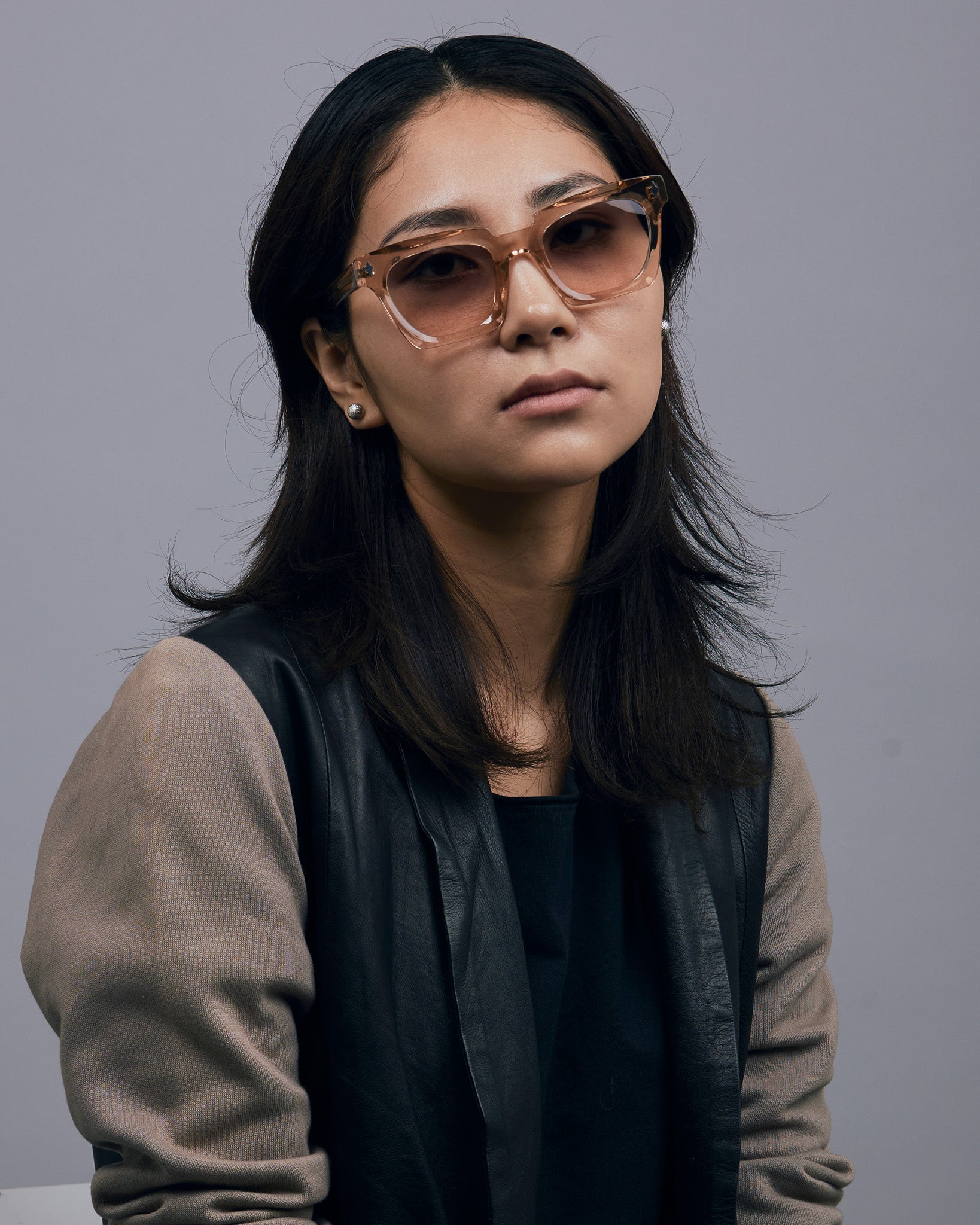 Brutal 1.0 Sunglasses by Tribu Eyewear — Champagne crystal acetate square frame, dusk tint lens, female model, grey background.