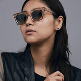 Brutal 1.0 Sunglasses by Tribu Eyewear — Champagne crystal acetate square frame, grey gradient polarised, female model, grey background.