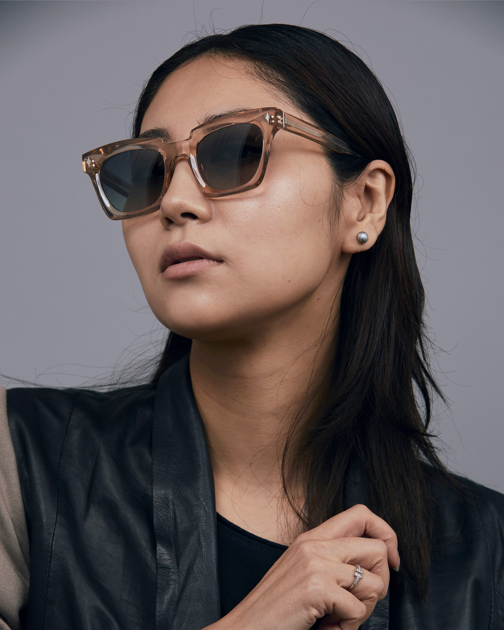 Brutal 1.0 Sunglasses by Tribu Eyewear — Champagne crystal acetate square frame, grey gradient polarised, female model, grey background.