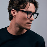 Brutal 1.0 Optical by Tribu Eyewear — Tortoiseshell square optical frame, male model side view in studio lighting. 