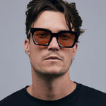 Brutal 1.0 Sunglasses by Tribu Eyewear — Tort acetate square frame, desert orange  lens on male model , grey background.