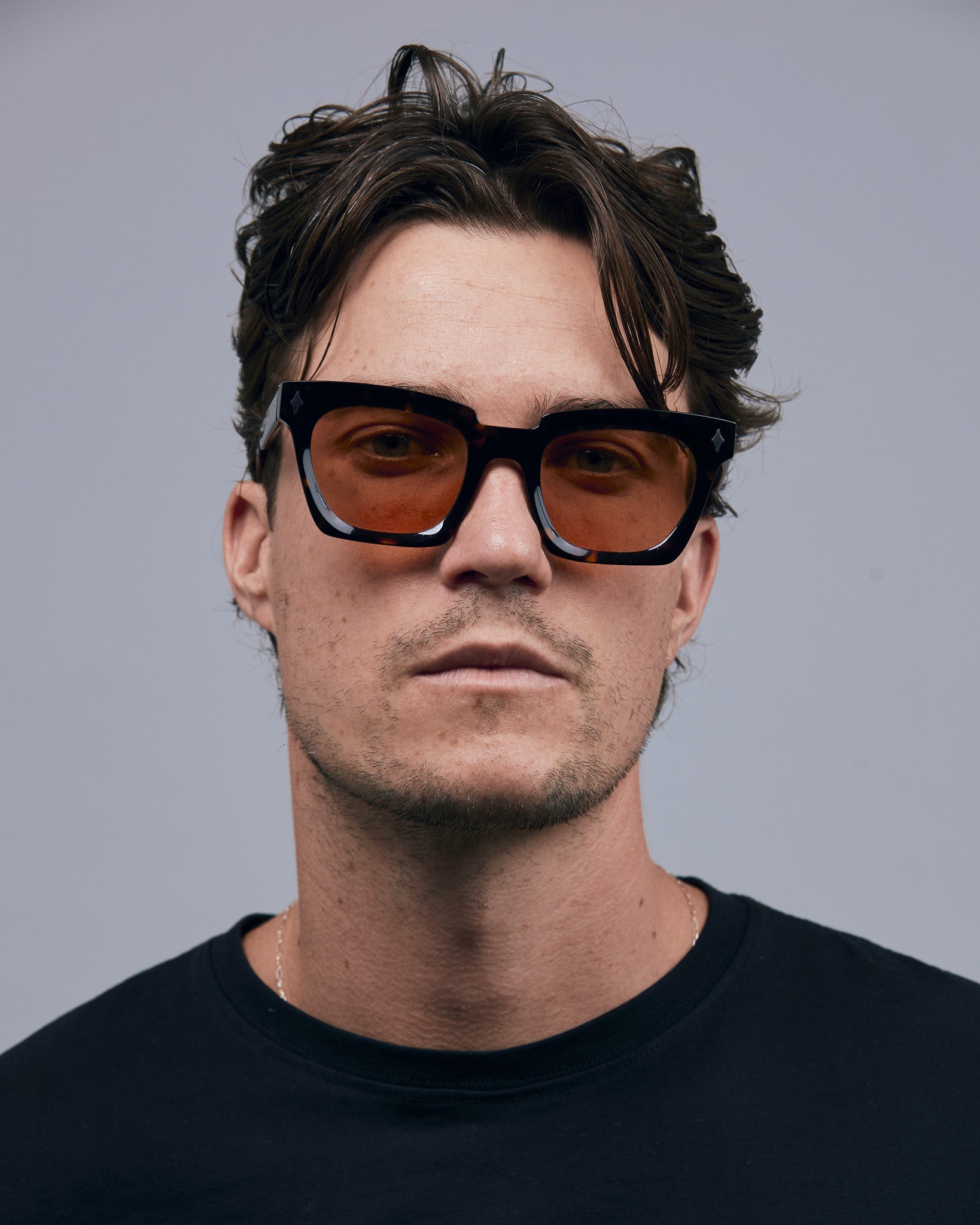 Brutal 1.0 Sunglasses by Tribu Eyewear — Tort acetate square frame, desert orange  lens on male model , grey background.