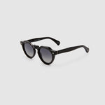 Brutal 2.0 Sunglasses by Tribu Eyewear — Grey grad polarised lens in a black round acetate frame, side view on grey background.