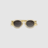Brutal 2.0 Sunglasses by Tribu Eyewear — Grey grad polarised lens in a Champagne crystal round acetate frame, flat view on grey background.