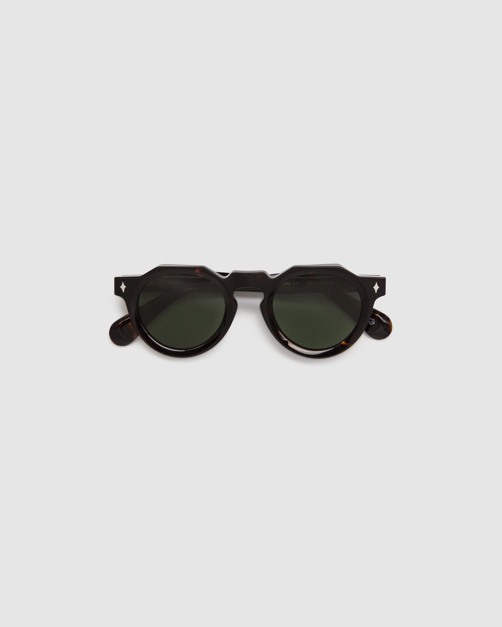 Brutal 2.0 Sunglasses by Tribu Eyewear — Green polarised lens in a round tort acetate frame, flat view on grey background.