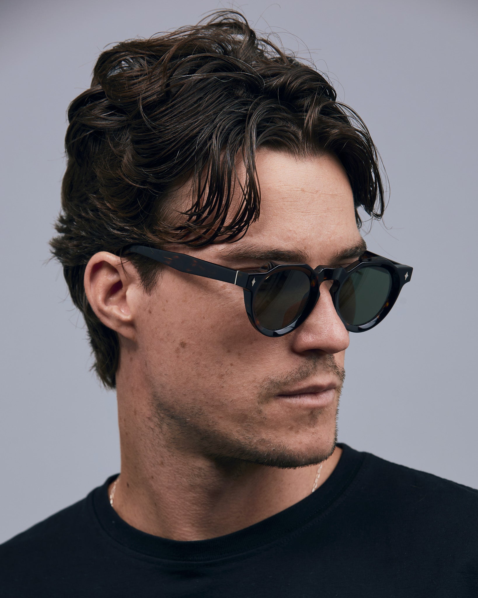 Brutal 2.0 Sunglasses by Tribu Eyewear — Green polarised lens in a round tort acetate frame on a male model.