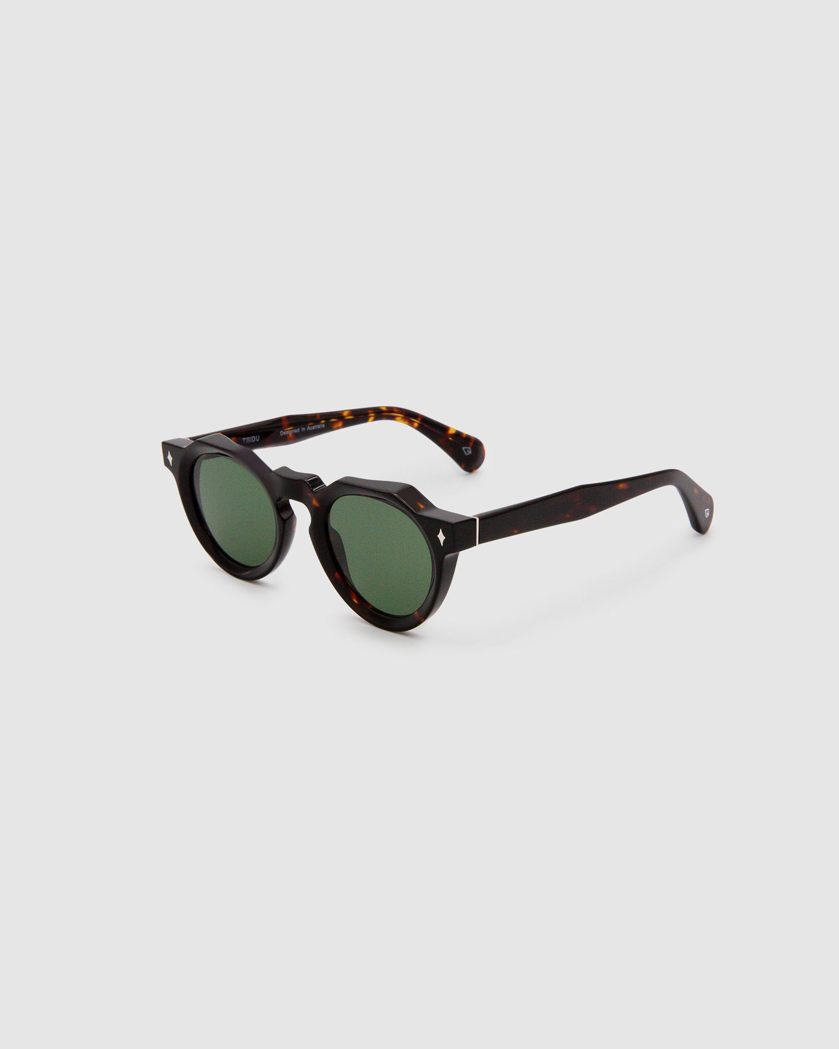Brutal 2.0 Sunglasses by Tribu Eyewear — Green polarised lens in a round tort acetate frame, side view on grey background.