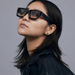 Brutal 3.0  Sunglasses by Tribu Eyewear — Black square acetate frame, dusk lens, on female model light grey background.