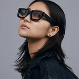 Brutal 3.0  Sunglasses by Tribu Eyewear — Black square acetate frame, dusk lens, on female model light grey background.