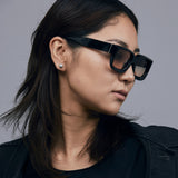 Brutal 3.0  Sunglasses by Tribu Eyewear — Black square acetate frame, dusk lens, on female model light grey background.