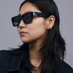 Brutal 3.0 Polarised Sunglasses by Tribu Eyewear — Black square frame, female model light grey background.