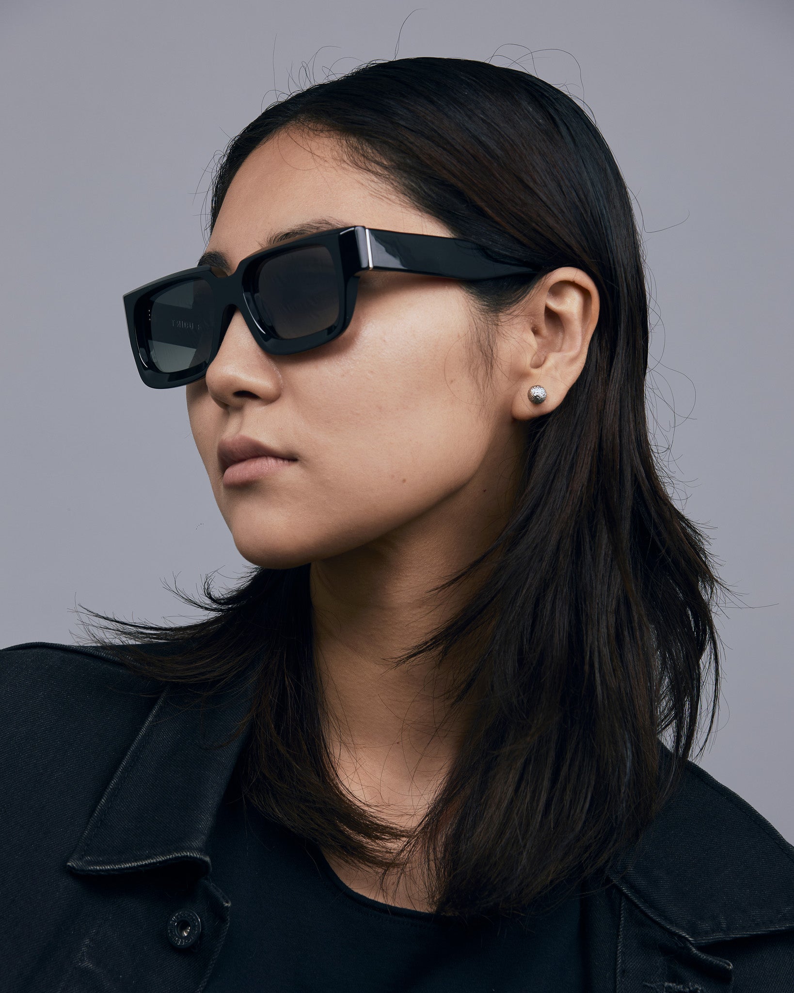 Brutal 3.0 Polarised Sunglasses by Tribu Eyewear — Black square frame, female model light grey background.