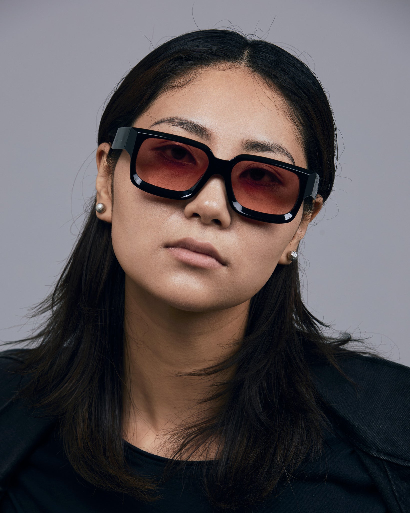 Brutal 3.0  Sunglasses by Tribu Eyewear — Black square acetate frame, sunset lens, female model light grey background.