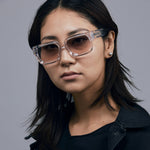 Brutal 3.0  Sunglasses by Tribu Eyewear — Crystal square acetate frame, dusk lens, female model light grey background.