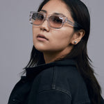 Brutal 3.0  Sunglasses by Tribu Eyewear — Crystal square acetate frame, dusk lens, female model light grey background.
