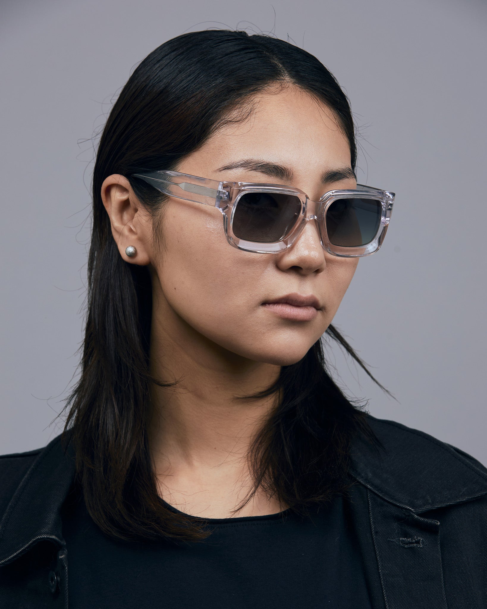 Brutal 3.0 Polarised Sunglasses by Tribu Eyewear — Crystal square acetate frame, female model light grey background.