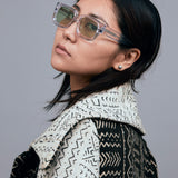 Brutal 3.0  Sunglasses by Tribu Eyewear — Crystal square acetate frame, sage lens, female model light grey background.